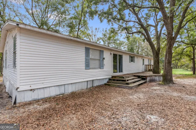 a backyard of a house with barbeque oven table and chairs