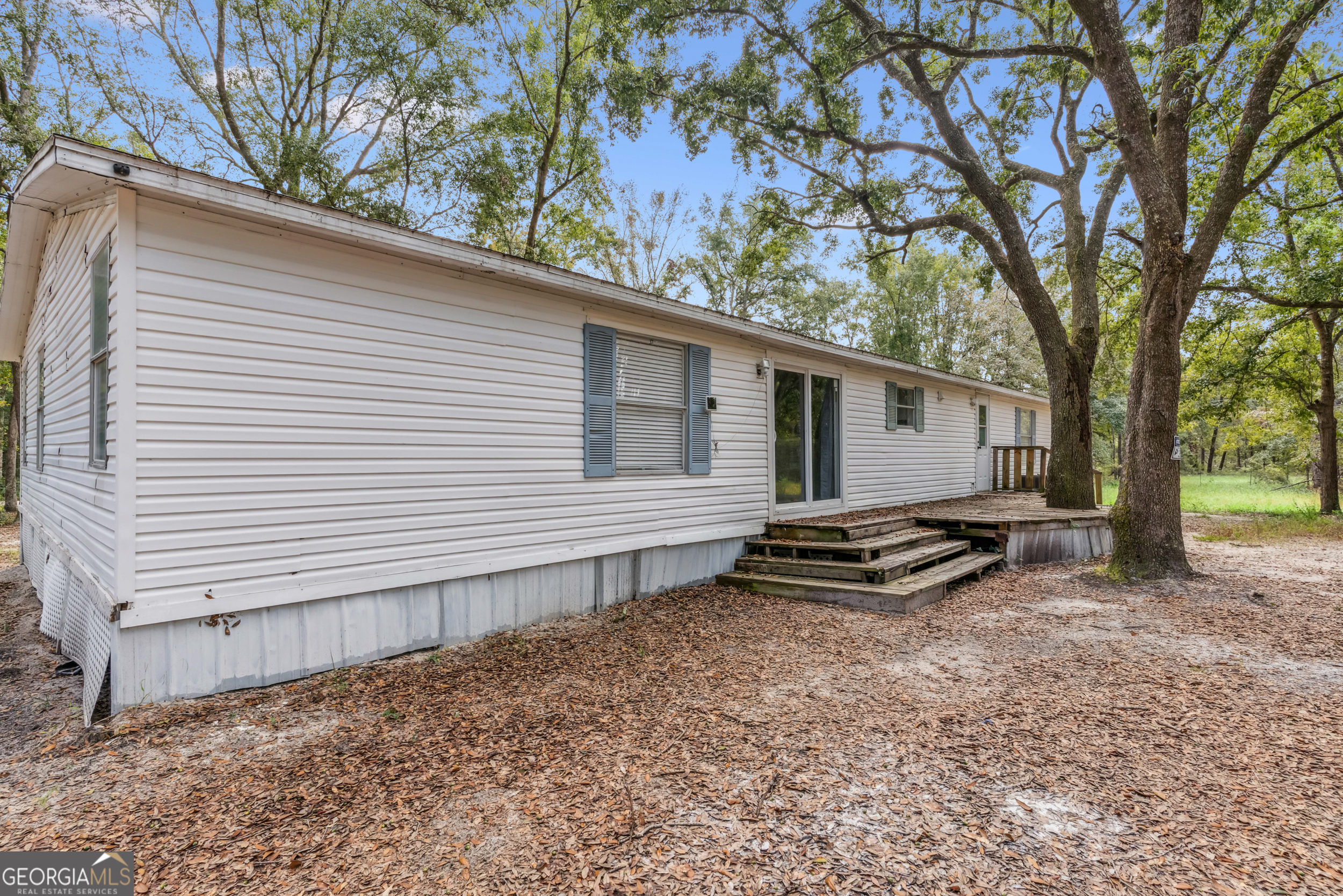 68 Amber Drive Waverly, GA 31565 - Photo 9 of 39 a backyard of a house with barbeque oven table and chairs
