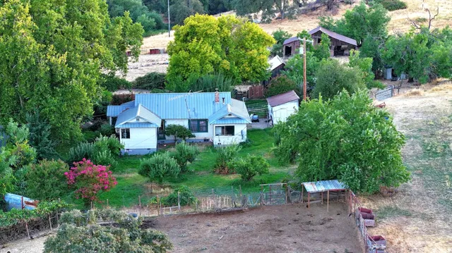 a kitchen with stainless steel appliances granite countertop a refrigerator a stove and a sink with wooden floor