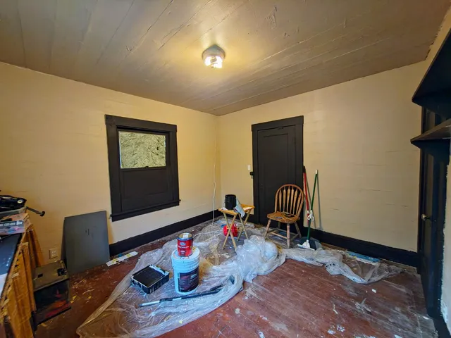 a red and white house with a flower garden in front of it