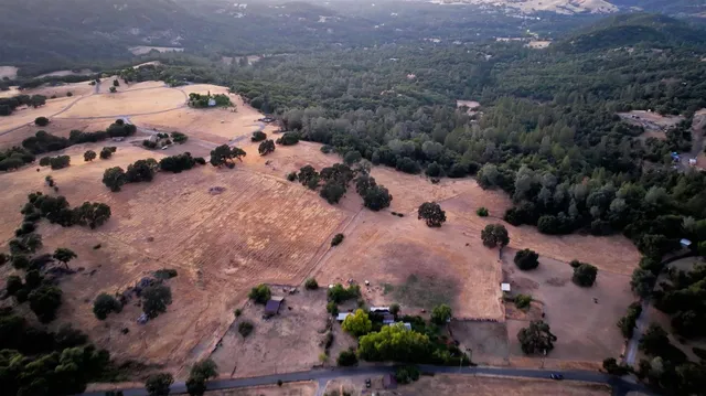 an aerial view of house with yard and swimming pool