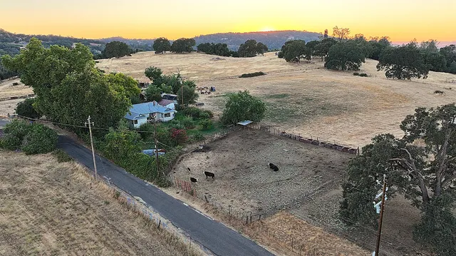 a view of a dry field with mountains in the background