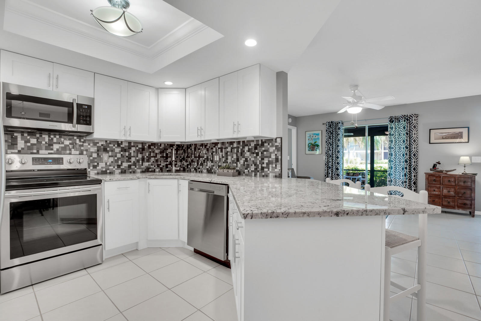 6544 Chasewood Drive, Unit D Jupiter, FL 33458 - Photo 2 of 16 a kitchen with stainless steel appliances granite countertop a stove a sink and a microwave