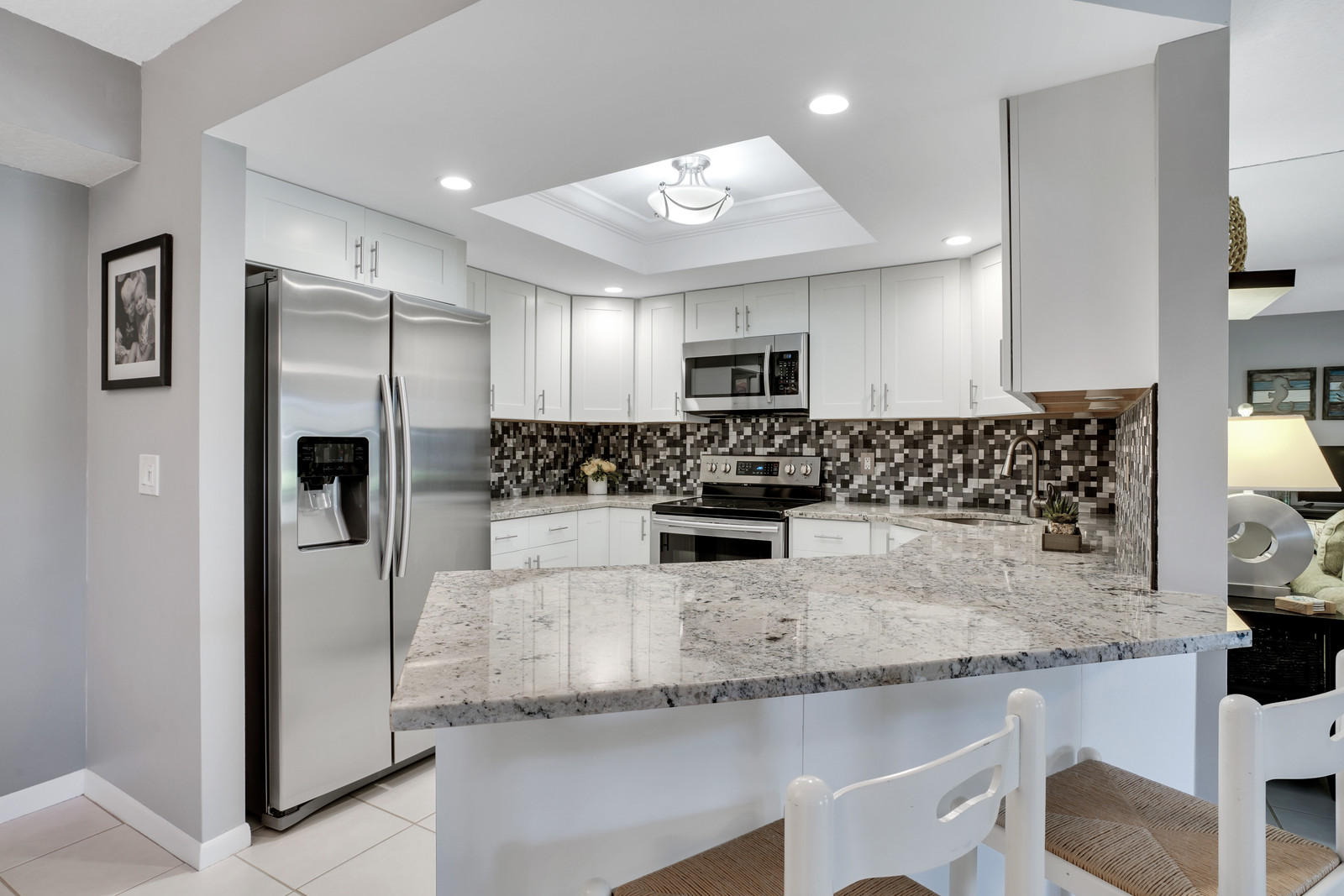 6544 Chasewood Drive, Unit D Jupiter, FL 33458 - Photo 4 of 16 a kitchen with a refrigerator a microwave a sink and cabinets