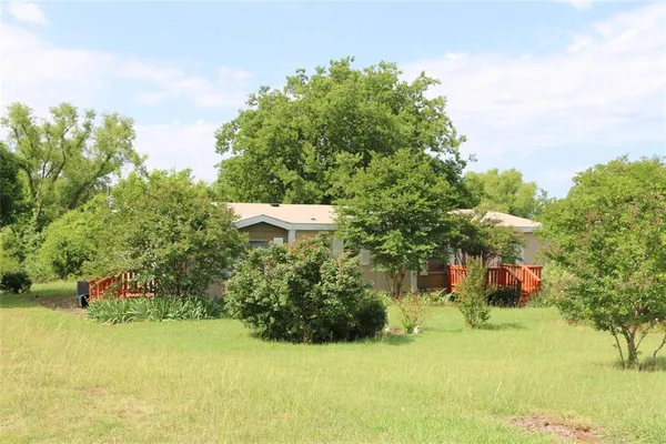 a backyard of a house with plants and tree