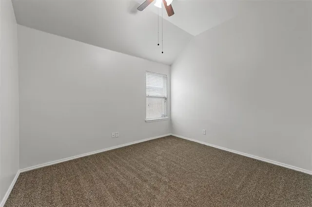 an empty room with a window and a ceiling fan