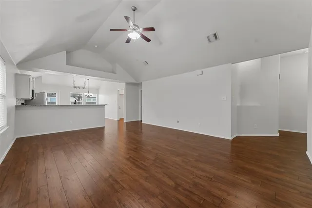 a view of a kitchen with a dishwasher a kitchen island hardwood floor and a ceiling fan