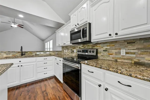 a kitchen with stainless steel appliances granite countertop a stove a sink and a microwave