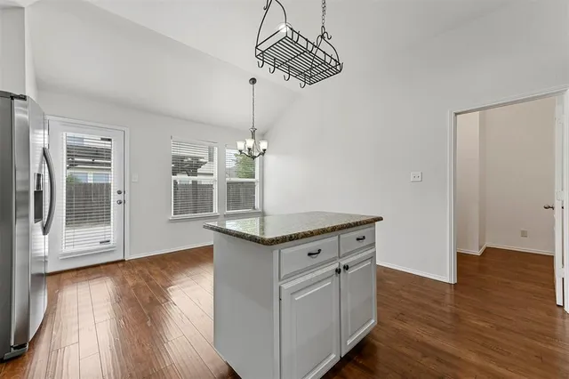 a kitchen with stainless steel appliances granite countertop a stove and a wooden floors