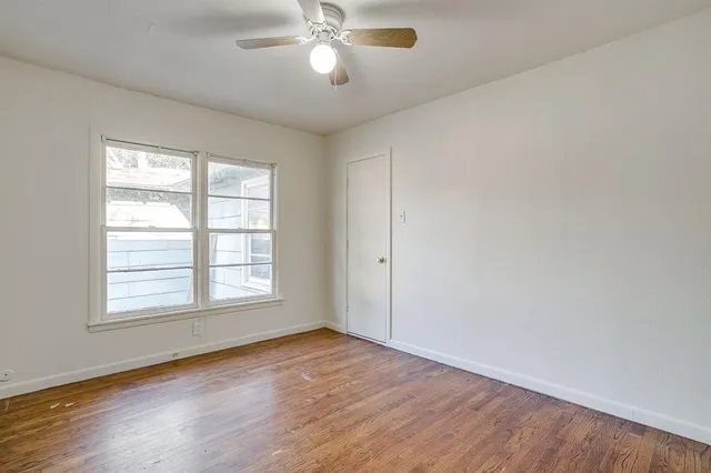 a view of an empty room with wooden floor