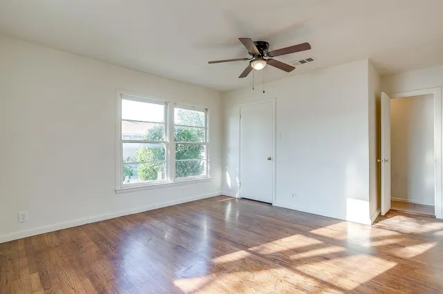 a view of a room with wooden floor and white walls