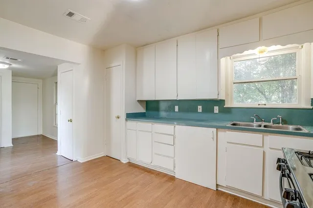 a view of an empty room with wooden floor