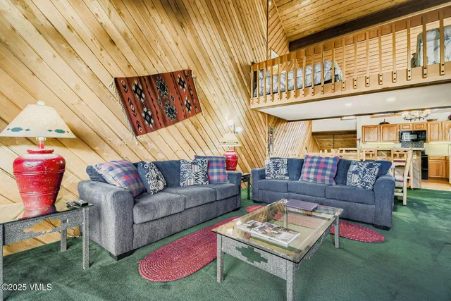 a living room with furniture a rug and a chandelier