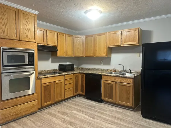 a kitchen with granite countertop a sink stainless steel appliances and cabinets