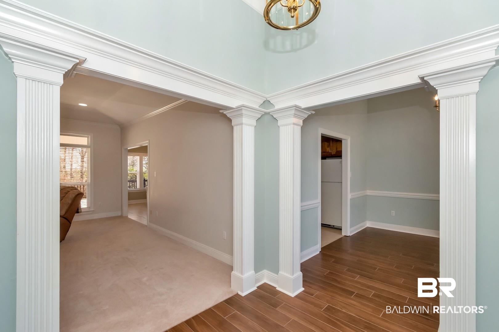 6090 Celeste Road Saraland, AL 36571 - Photo 3 of 38 Hallway featuring dark wood-style floors, decorative columns, baseboards, and ornamental molding