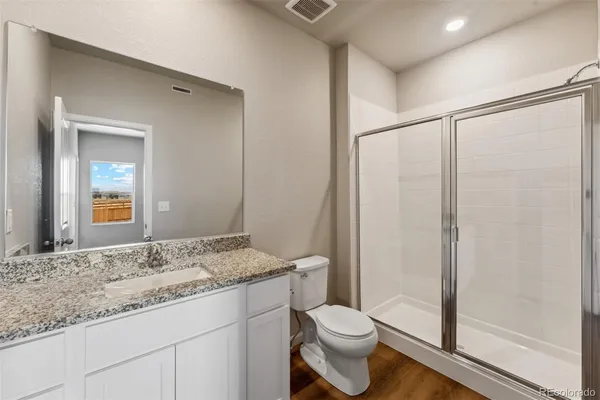 a bathroom with a granite countertop sink toilet and shower