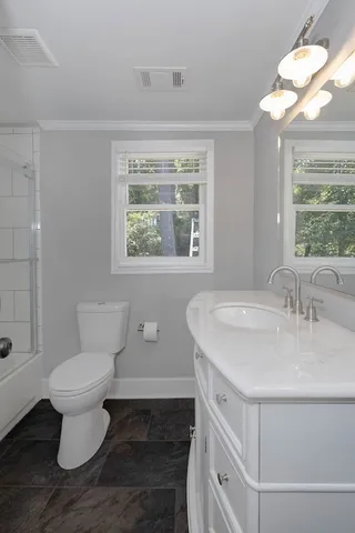 a bathroom with a sink toilet and a window