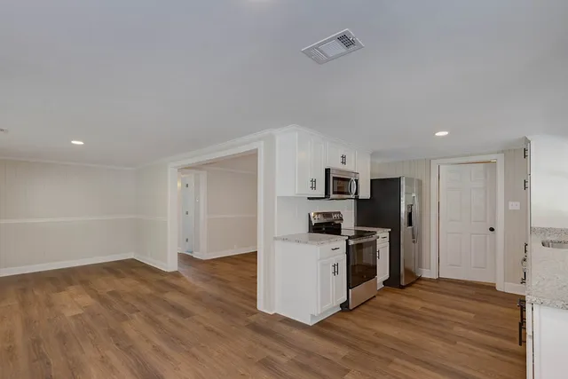 a view of a kitchen with a sink wooden floor and a refrigerator