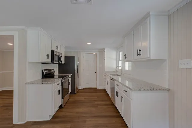 a kitchen with stainless steel appliances granite countertop a stove and a refrigerator