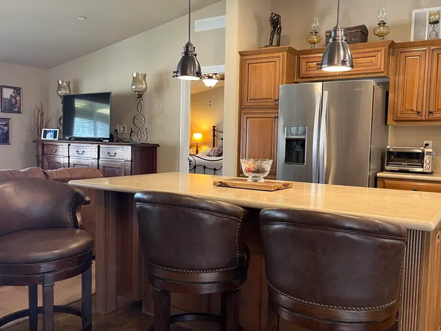 a kitchen with stainless steel appliances granite countertop a sink a stove a refrigerator a washer and dryer