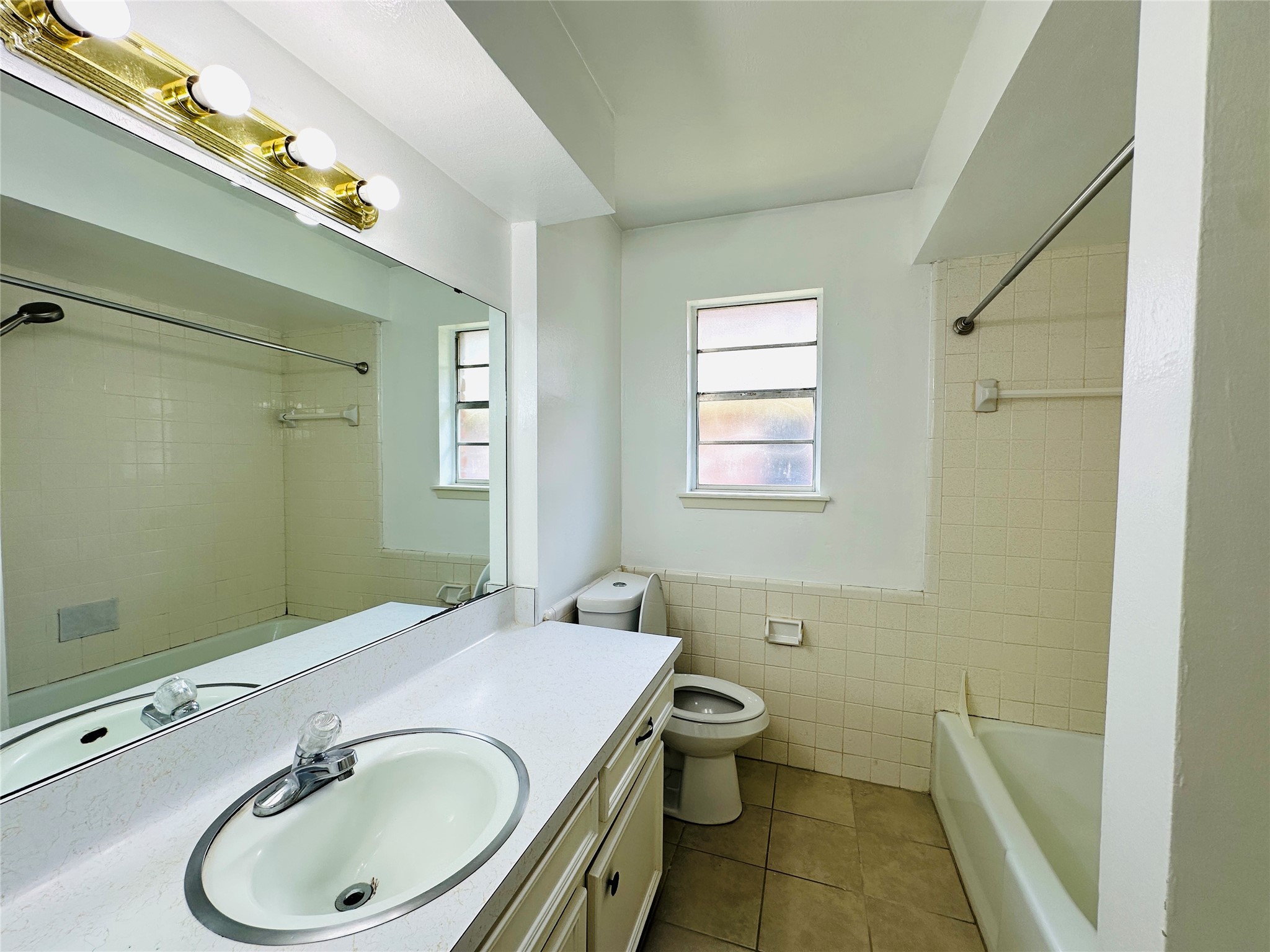 1011 Mccall Avenue Conroe, TX 77301 - Photo 11 of 15 a bathroom with a sink a toilet and a mirror