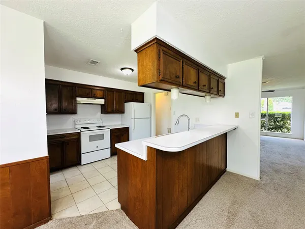 a kitchen with stainless steel appliances a sink a stove top oven a counter space and cabinets