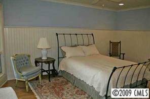 15131 Birling Road Charlotte, NC 28278 - Photo 4 of 12 a bedroom with a bed and a table in it