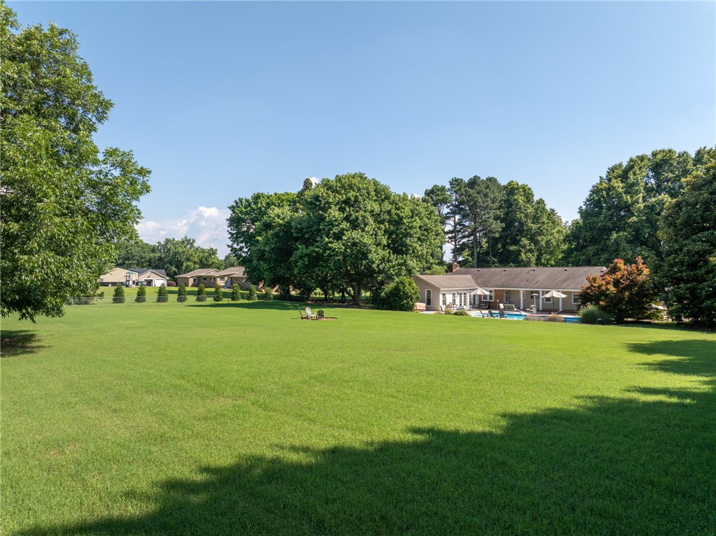 3513 Hopewell Road Anderson, SC 29621 - Photo 40 of 50 A sprawling green yard provides ample space for recreation, complemented by a private pool and mature trees.