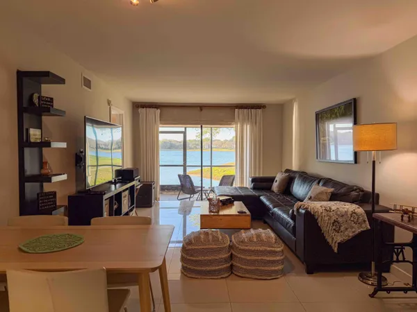 a living room with furniture a lamp and large window