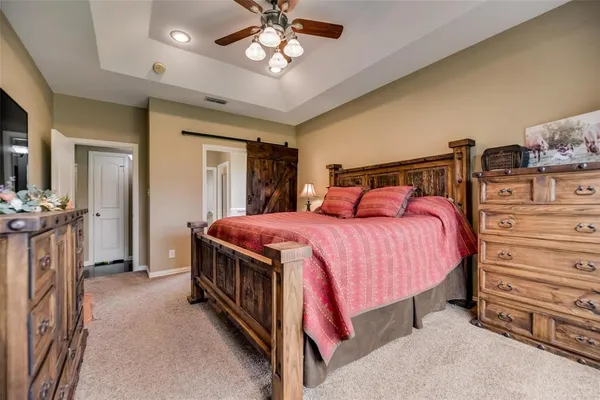 a spacious bedroom with a bed and a chandelier