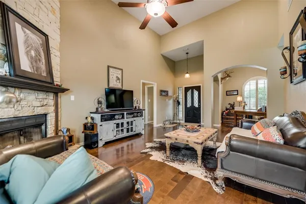 a living room with furniture a flat screen tv and a fireplace