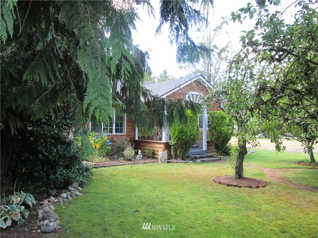 19039 Loganberry Street Southwest Rochester, WA 98579 - Photo 1 of 25 a front view of a house with garden and trees