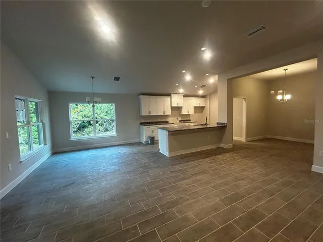 a view of kitchen with kitchen island a sink wooden floor and a refrigerator
