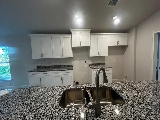a kitchen with a sink a stove and cabinets