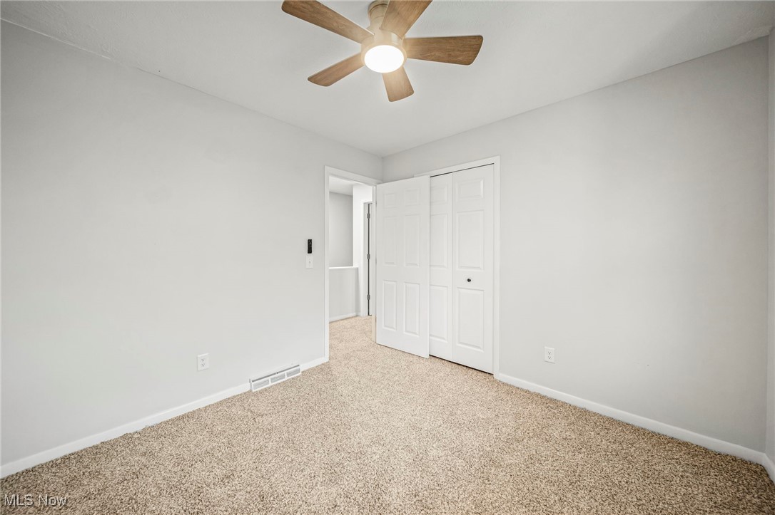 91 Paradise Road Painesville, OH 44077 - Photo 25 of 39 Unfurnished bedroom with carpet flooring, a closet, and a ceiling fan