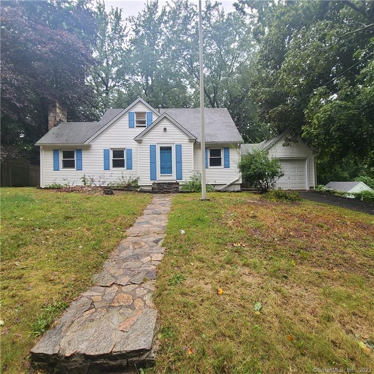 a front view of a house with a yard and trees