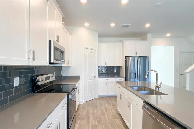 a kitchen with a refrigerator a sink and a stove