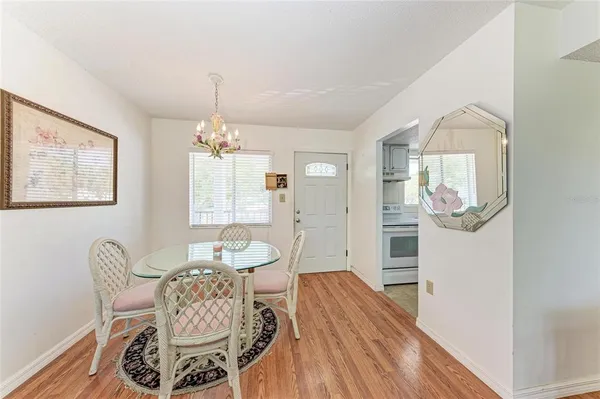 a dining room with furniture a chandelier and wooden floor