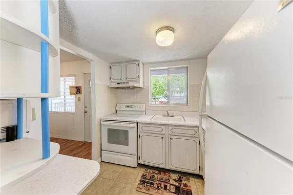 a kitchen with white cabinets and white appliances