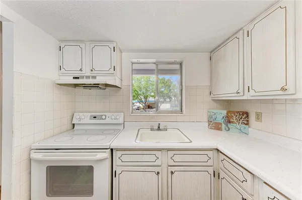 a kitchen with white cabinets and a sink