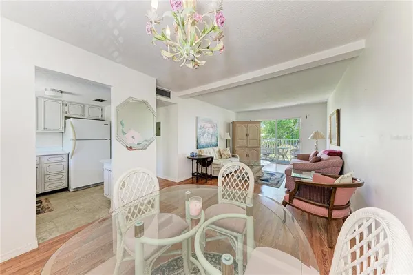 a living room with furniture a chandelier and a large mirror next to a window