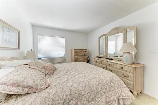 a bedroom with a bed and a dresser with mirror