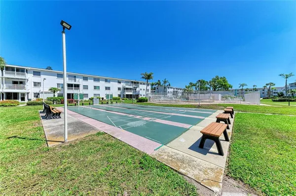 a view of a tennis ground with a big yard and plants