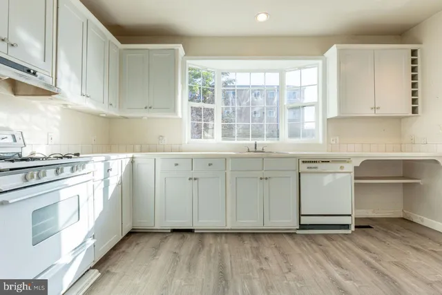 a kitchen with granite countertop white cabinets and white appliances
