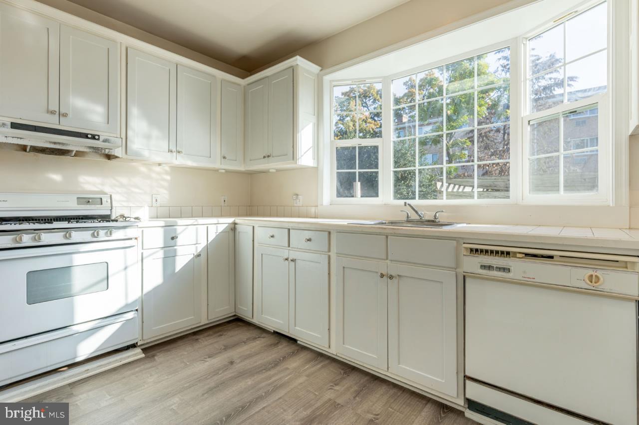 415 South Adams Street Arlington, VA 22204 - Photo 16 of 36 a kitchen with granite countertop white cabinets and white appliances