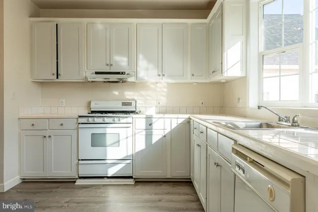 a kitchen with stainless steel appliances granite countertop a sink stove and cabinets
