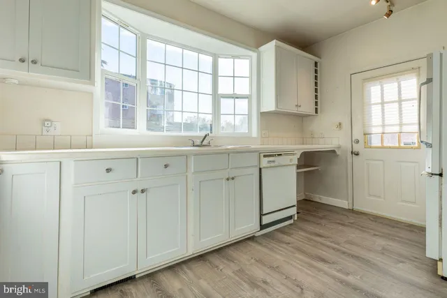 a kitchen with a sink cabinets appliances and a window