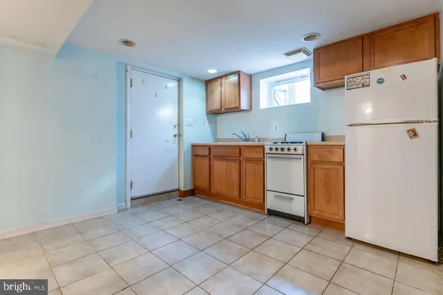 a kitchen with stainless steel appliances granite countertop a refrigerator a stove and a sink