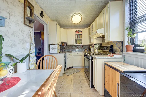 a kitchen that has a sink a stove and chairs
