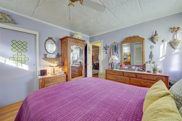 a bedroom with a bed and a large mirror on the dresser